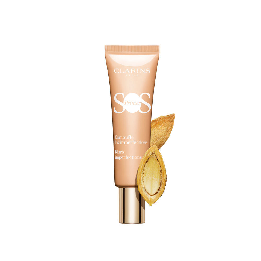 A tube of SOS Primer Peach by Clarins, which blurs imperfections and evens skin tone, featuring a desert date.