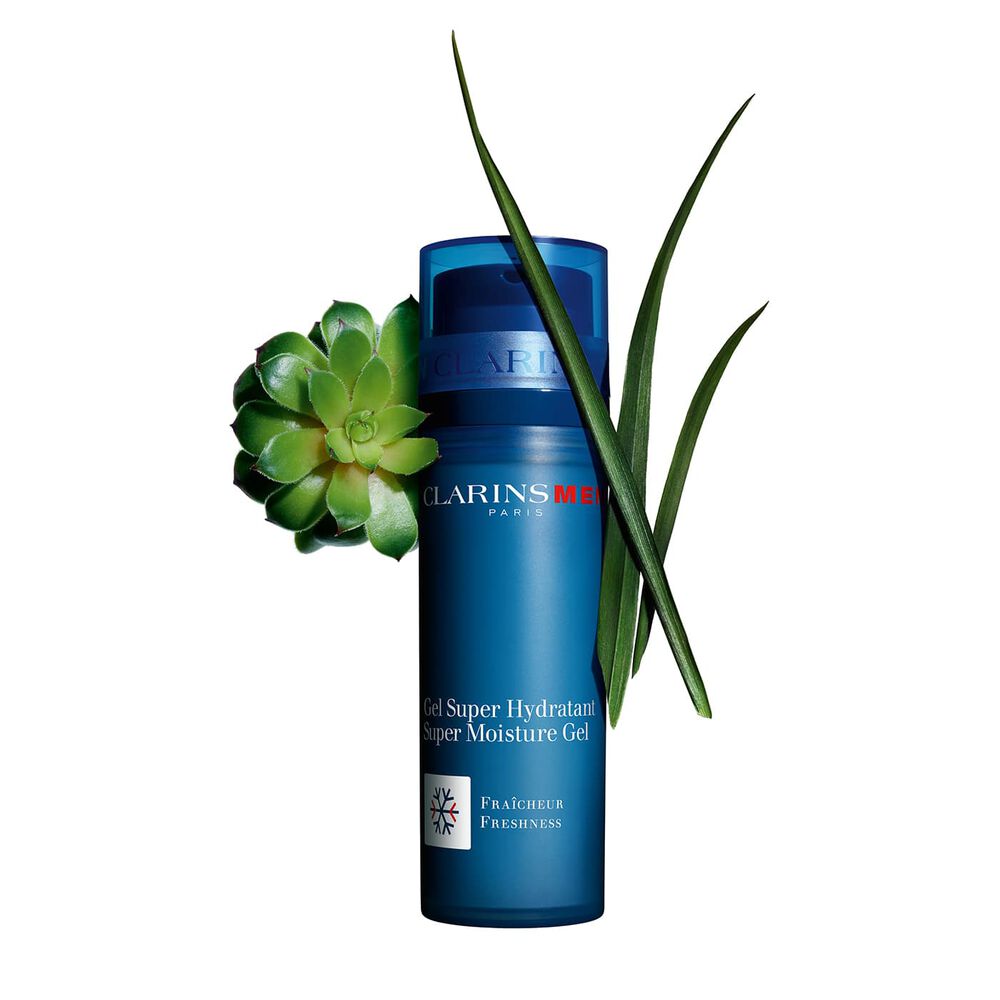Packshot of a pump bottle of the Men Super Moisture Gel by Clarins close to gymnena and bison grass on a blue background.