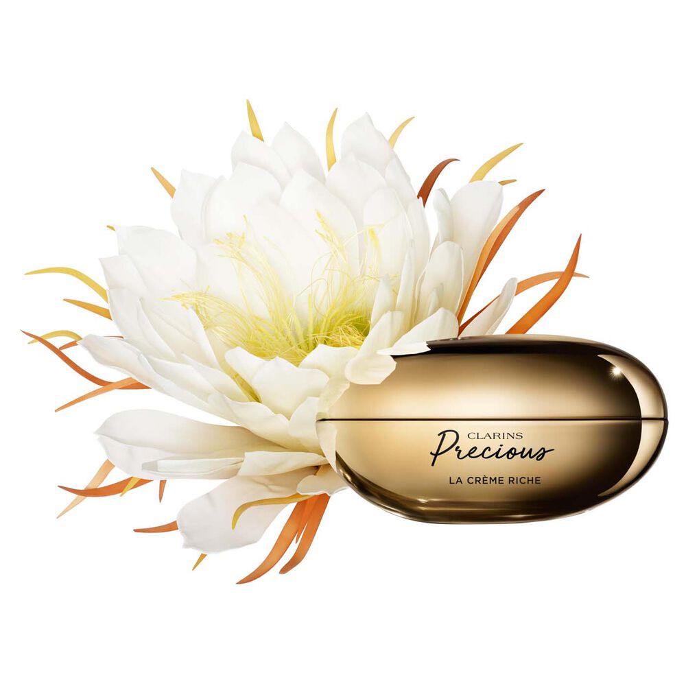 Packshot of Clarins Precious Rich Cream close to a Moonlight flower on dark background.