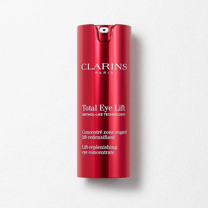 Packshot of Clarins Total Eye Lift anti-aging eye cream with harungana leaves on a dark red background.