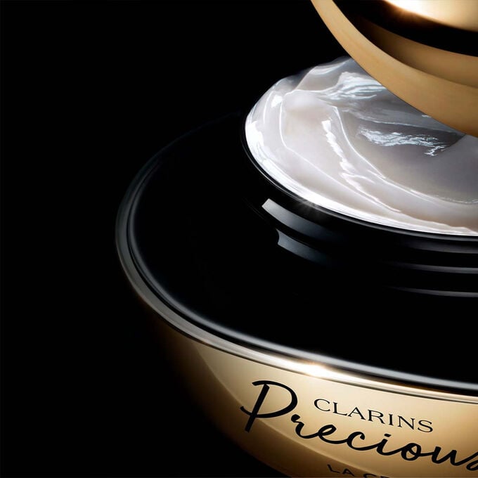 Packshot of Clarins Precious Soft Cream on dark background, with text emphasising its power to make skin appear 5 years younger.