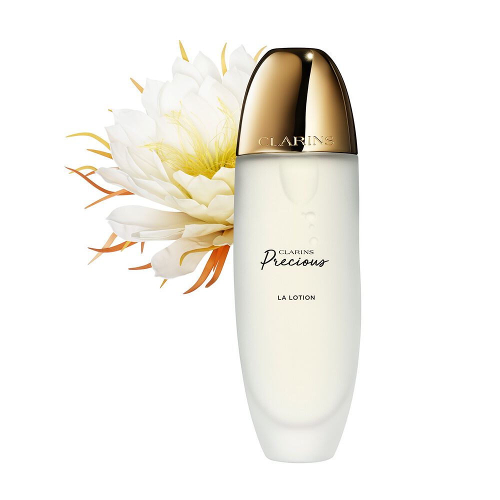 Packshot of Clarins Precious Treatment Essence close to a Moonlight flower on a dark background.
