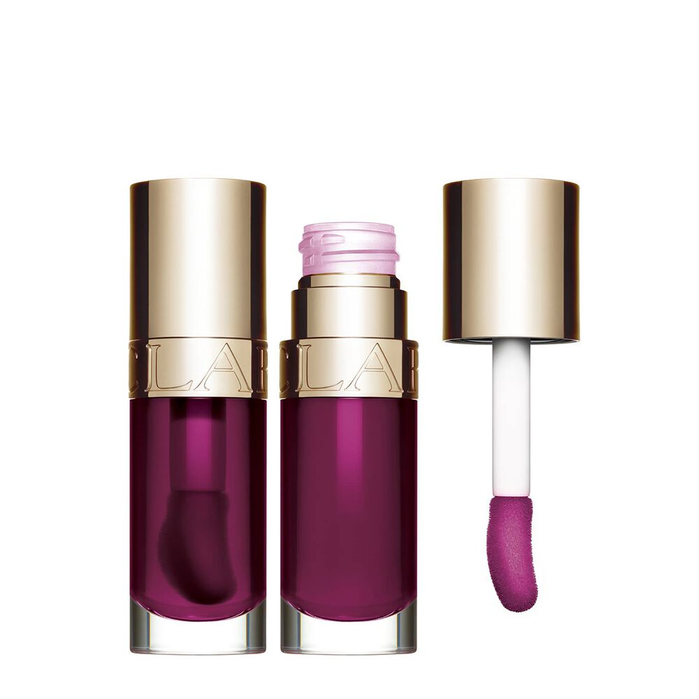 Packshot of Clarins Lip Comfort Oil Plum, placed next to a sweetbriar rose on a light pink background.