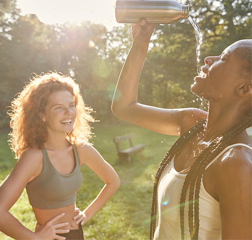 two young women drinking water and laughing